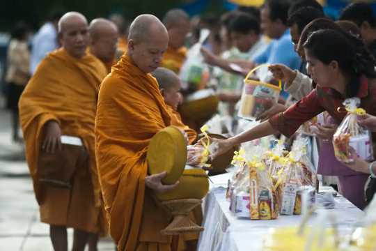 Thai Buddhist monks accepting food donations